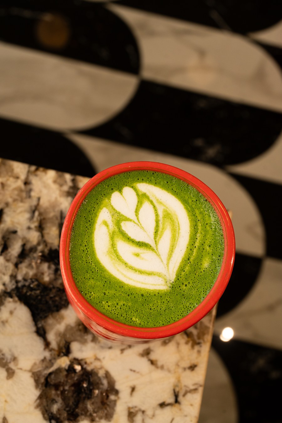 Matcha latte con arte visto desde arriba en taza roja