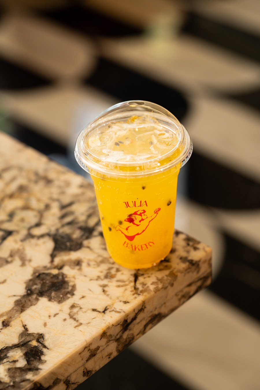 Refresher frío en vaso con el logo de Julia Bakery